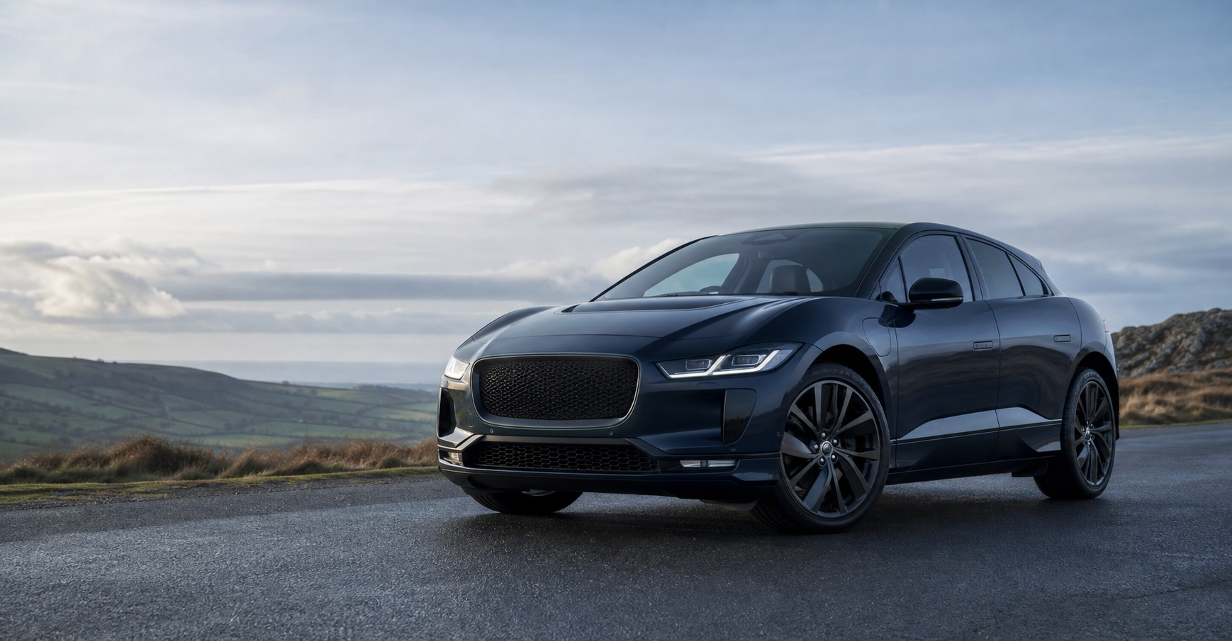 A dark electric SUV on a quiet road, representing the Jaguar I-PACE owners' group